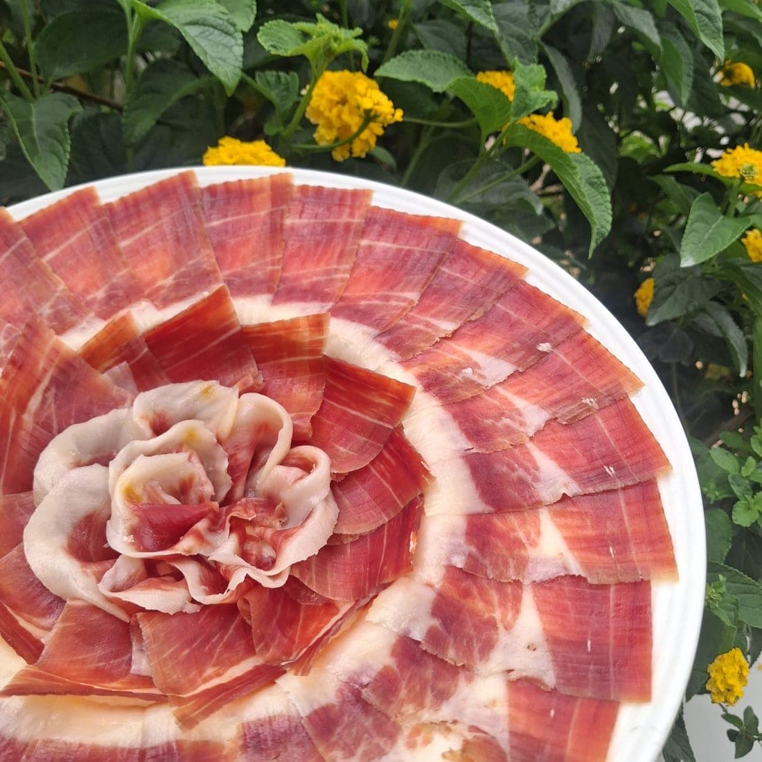 Plato de jamón cortado a cuchillo y emplatado en forma de flor
